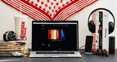 LONDON, UK - SEP 13, 2018: Creative room table with Safari Browser on MacBook Pro laptop showcasing Apple Computers website latest iPhone Xr smartphone with, red, blue, yellow, white, and black finishのeditorial素材