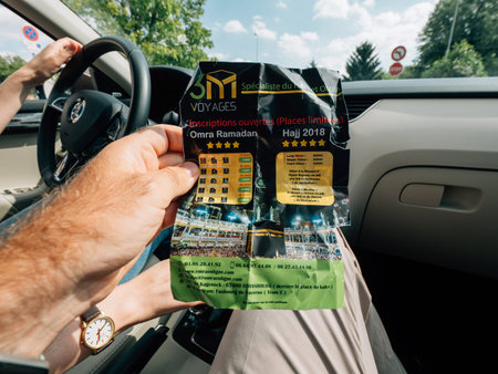 STRASBOURG, FRANCE - SEP 15, 2018: Man POV holding flyer with Omra and Hajj excursions inside...