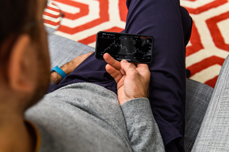 LONDON, UK - SEP 21, 2018: Man using the new Apple iPhone Xs with the immense OLED retina display and a12 bionic chip, looking over the app application SSTK stock market shutterstock appのeditorial素材