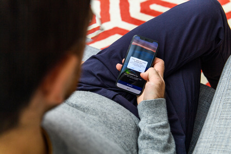 LONDON, UK - SEP 21, 2018: Man using the new Apple iPhone Xs with the immense OLED retina display and a12 bionic chip, looking over the app applicationのeditorial素材
