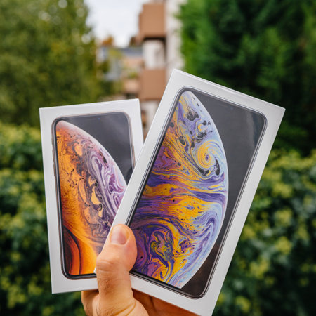 PARIS, FRANCE - SEP 21, 2018: Proud man customer POV comparing the new latest iPhone Xs and Xs Max smartphones telephones before the unboxing against green backgroundのeditorial素材