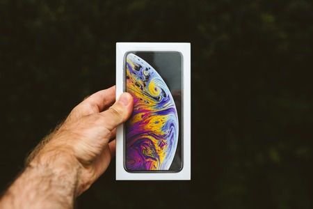 PARIS, FRANCE - SEP 21, 2018: Proud man customer POV comparing the new latest iPhone Xs Max smartphone telephone before the unboxing against green backgroundのeditorial素材