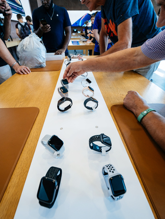 STRASBOURG, FRANCE - SEP 21, 2018: Hand of senior man in Apple Store and other customers admiring the new latest Apple Watch Series 4 wearable smartwatchのeditorial素材