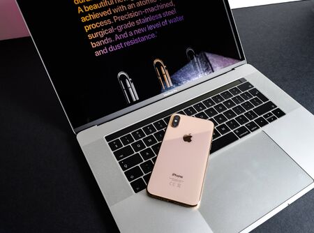 PARIS, FRANCE - SEP 25, 2018: New iPhone Xs and Xs Max smartphone model by Apple Computers close up of the newest golden Apple Iphone device on MacBook pro keyboardのeditorial素材