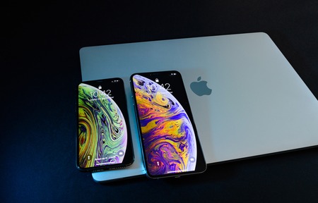 PARIS, FRANCE - SEP 25, 2018: Side by side two new iPhone Xs and Xs Max smartphone model by Apple Computers close up on laptop MacBook pro closed lid.のeditorial素材