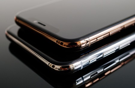 PARIS, FRANCE - SEP 25, 2018: One above another iPhone Xs and Xs Max smartphone model by Apple Computers close up of newest golden silver iPhone mobile phone device on modern technology backgroundのeditorial素材