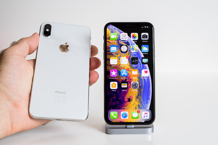 PARIS, FRANCE - SEP 25, 2018: Male hand compare new iPhone Xs and Xs Max smartphone model by Apple Computers close up with man holding the white oneのeditorial素材
