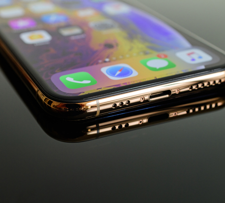 PARIS, FRANCE - SEP 25, 2018: New iPhone Xs and Xs Max smartphone model by Apple Computers close up lighting connector close-up macro of golden version - macro artistic photoのeditorial素材