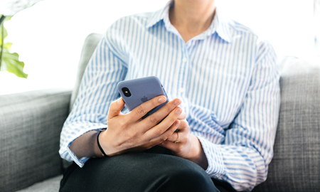 PARIS, FRANCE - SEP 27, 2018: Careful business woman testing the silicone protection case after unboxing for latest iPhone Xs and Xs Max smartphone telephoneのeditorial素材