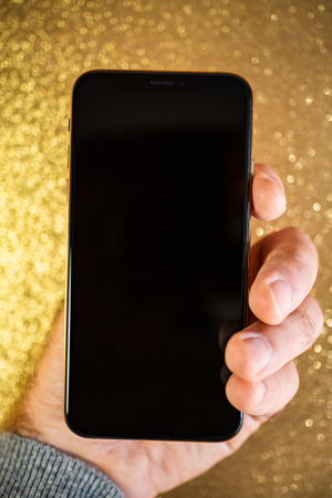 PARIS, FRANCE - SEP 27, 2018: Apple Computers iPhone Xs and Xs Max as hero object on gold glitter glamorous background - smartphone telephone with OLED display from Apple Computers black displayのeditorial素材