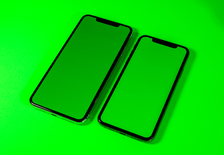 Blacnk green chroma key on new mobile smartphne as hero object on bright glamorous modern neon pop green background - smartphone telephone ready for your appの写真素材