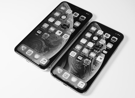 PARIS, FRANCE - SEP 27, 2018: Compare the new Apple Computers iPhone Xs and Xs Max as hero object on bright glamorous modern neon pop yellow background - smartphone black and whiteのeditorial素材