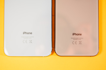PARIS, FRANCE - SEP 27, 2018: Apple Computers iPhone Xs and Xs Max as hero object on bright glamorous modern neon pop orange background - smartphone telephone with OLED display rear glassのeditorial素材