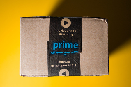 PARIS, FRANCE - SEP 28, 2018: Directly above view of New Amazon Cardboard box against yellow background. Amazon Prime is the online paid subscription service offered by Amazon.com web-commerce site - security scotch tapeのeditorial素材