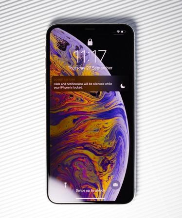 PARIS, FRANCE - SEP 27, 2018: new iPhone Xs Max smartphone model by Apple Computers close up with lock screen and wallpaper against stripes white background do not disturbのeditorial素材
