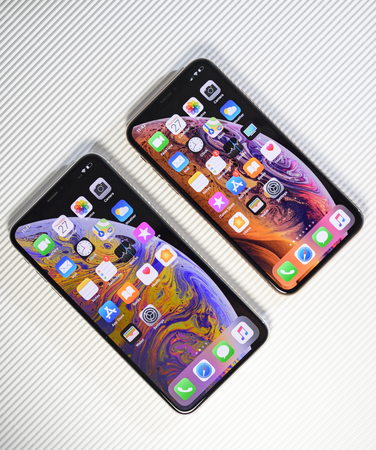 PARIS, FRANCE - SEP 27, 2018: Compare the new Apple Computers iPhone Xs and Xs Max with home apps on the gorgeous OLED display on stripe cardboard backgroundのeditorial素材