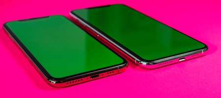 PARIS, FRANCE - SEP 27, 2018: Side-by-side of two Apple Computers iPhone Xs and Xs Max as hero object on bright glamorous modern neon pop fuchsia background - smartphone telephone with OLED displayのeditorial素材