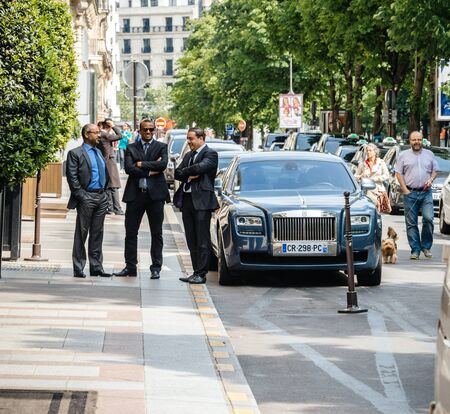 PARIS, FRANCE - MAY 21, 2016: Drivers and security personnel talking near elegant Rolls-Royce car parked in front of George V luxury hotel in Parisのeditorial素材