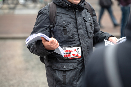 STRASBOURG, FRANCE - MAR 22, 2018: People gathering in Place Kleber square during CGT General Confederation of Labour demonstration protest against Macron French government string of reforms - man distributing flyers manifestsのeditorial素材