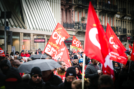 STRASBOURG, FRANCE - MAR 22, 2018: CGT General Confederation of Labour workers with placard at demonstration protest against Macron French government string of reforms - closed central street people with flagsのeditorial素材