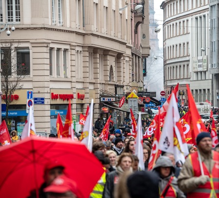 STRASBOURG, FRANCE - MAR 22, 2018: CGT General Confederation of Labour workers with placard at demonstration protest against Macron French government string of reforms - french streets full with people - perspective view with smoke grenadeのeditorial素材