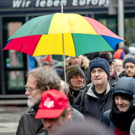 STRASBOURG, FRANCE - MAR 22, 2018: CGT General Confederation of Labour workers with placard at demonstration protest against Macron French government string of reforms - man with multicolored umbrellaのeditorial素材