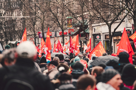STRASBOURG, FRANCE - MAR 22, 2018: CGT General Confederation of Labour workers with placard at demonstration protest against Macron French government string of reforms - red flags on closed streetのeditorial素材