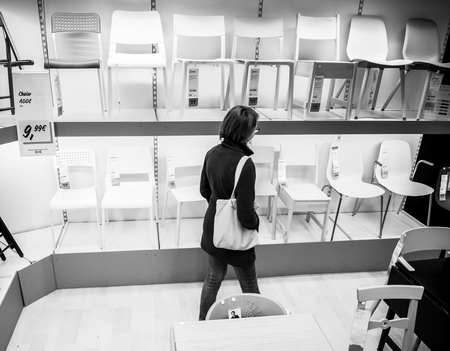 PARIS, FRANCE - SEP 9, 2017: View from above of French adult woman shopping for chairs furniture in the IKEA shopping furniture mall center black and whiteのeditorial素材