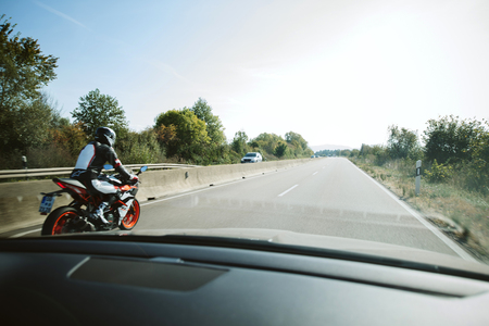 GERMANY - OCT 7, 2018: Driver POV at the fast motion motorcyclist on German Autobahn highwayのeditorial素材