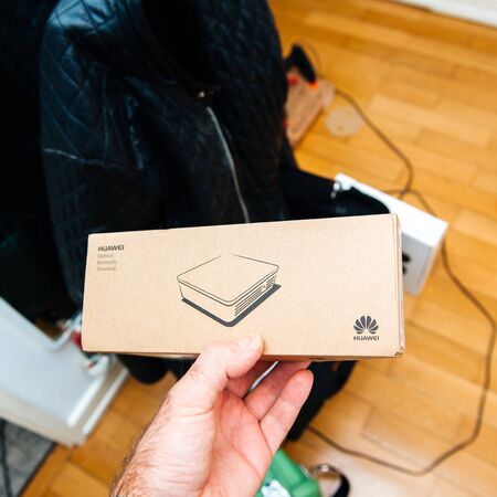 PARIS, FRANCE - JAN 15, 2018: Technician hand holding HUAWEI optical network terminal during fiber optic FTTh installation in apartment houseのeditorial素材