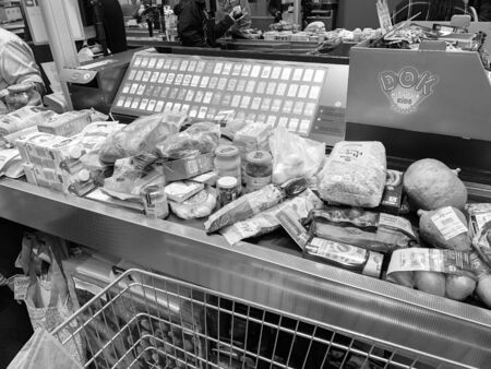 MUNICH, GERMANY - OCT 27, 2018: Cash desk with lots of food and non food products on the checkout counter - black and whiteのeditorial素材