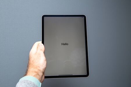 PARIS, FRANCE - NOV 14, 2018: Man holding the new iPad Pro tablet by Apple Computers against gray background - new most powerful tablet computer from Apple with faceID and A12x CPUのeditorial素材