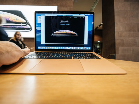 PARIS, FRANCE - NOV 8, 2018: Man hand touching the new  Apple MacBook Air thin laptop featuring...
