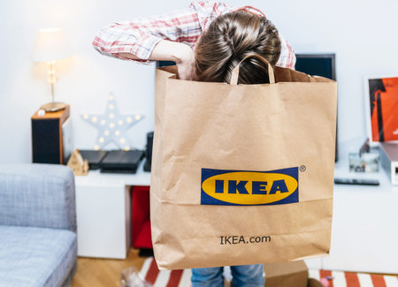 PARIS, FRANCE - DEC 2, 2018: Elegant French woman holding big paper IKEA bag full with merchandise...