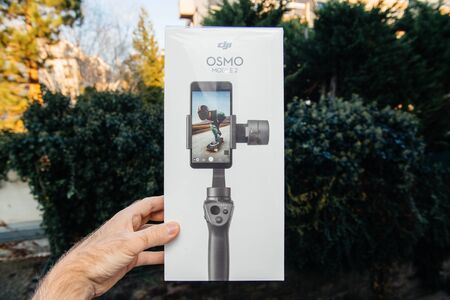 PARIS, FRANCE - NOV 22, 2018: Man hand holding in outdoor background new DJI Osmo Mobile 2 Smartphone Gimbal manufactured by the SZ DJI Technology Co., Ltd company horizontalのeditorial素材