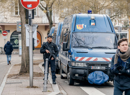 STRASBOURG, FRANCE - DEC 11, 2018: Police officer with rifle near blue van surveilling area after...