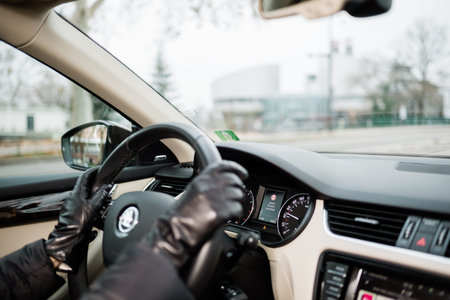 STRASBOURG, FRANCE - DEC 26, 2018: Woman driving Skoda Octavia Czech car wearing leather gloves with focus on 50km h exceeded sign on the dashboard computerのeditorial素材