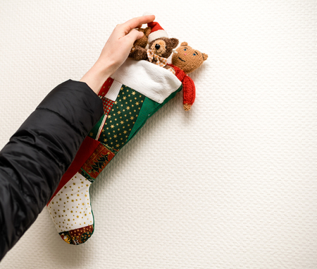 Woman decorating arranging Christmas stocking decoration on the wall - ready to receive the winter presentsの写真素材