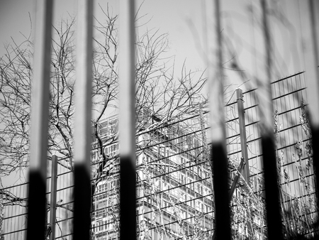 Abstract view of business building seen through security fences - black and whiteの写真素材