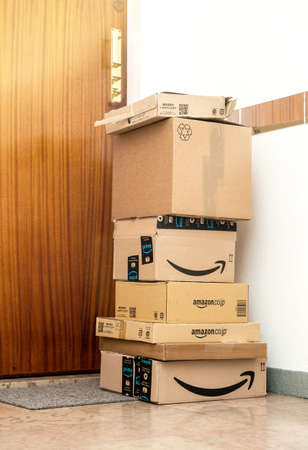 Paris, France - Nov 15, 2018: Stack of multiple Amazon Japan France, America United Kingdom Prime cardboard parcel boxes arranged by postal services near the apartment entrance doorのeditorial素材