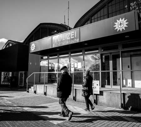 HAMBURG, GERMANY - MAR 20, 2018: Senior man and woman passing by Police Polizei station near Hamburg central railway stationのeditorial素材