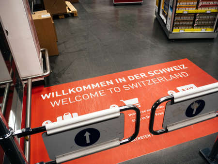 BASEL, SWITZERLAND - MAR 22, 2018: Welcome to Switzerland signage on the floor of Basel airport terminal sign see behind security gate entrance Dutty Freeのeditorial素材