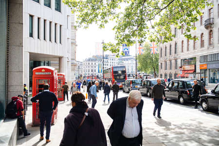 LONDON, UNITED KINGDOM - MAY 18, 2018: Strand street with Red double deckers, pedestrians, London telephone booths - typically Britainのeditorial素材