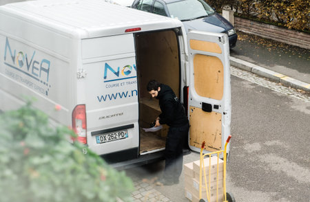 Paris, France - Nov 14, 2018: Man unloading on carriage trolley from delivery Fiat Ducato truck...