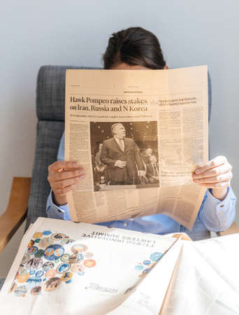 Paris, France - Mar 16, 2018: Young business woman reading Financial Times newsletter with main article featuring Mike Pompeoのeditorial素材