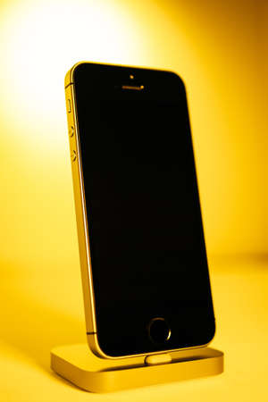 Paris, France - Apr 21, 2016: Hero object of newest Apple Computers iPhone SE smartphone after unboxing on yello background featuring new form factorのeditorial素材