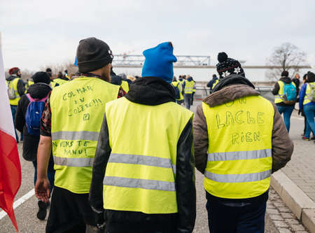 STRASBOURG, FRANCE - FEB 02, 2018: Friends demonstrating during protest of Gilets Jaunes Yellow Vest against Emmanuel Macron and actual government multiple inscriptions on vestsのeditorial素材