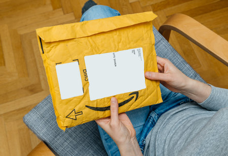 PARIS, FRANCE - NOV 4, 2017: Woman preparing to unpack unbox on the living room armchair the Amazon...
