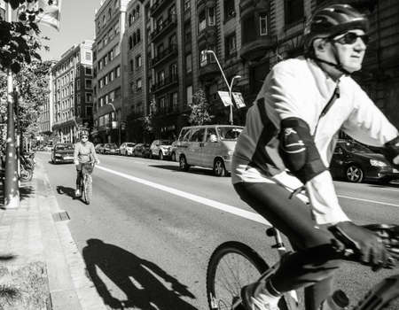 Barcelona, Spain - Nov 12, 2017: Senior couple cycling in central Barcelona early in the morning wearing helmets black and whiteのeditorial素材