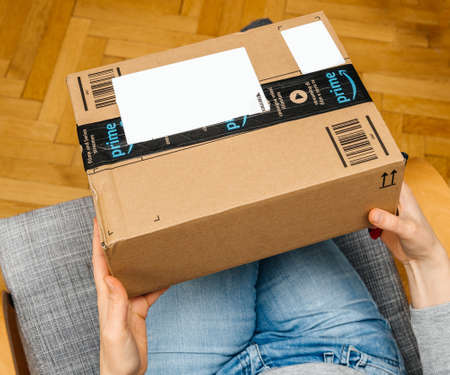PARIS, FRANCE - NOV 4, 2017: Woman point of view holding new Amazon Prime large cardboard box with Prime sealing tapeのeditorial素材